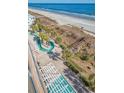 An aerial view of a beachside resort's landscaping and walkway to a sandy beach with ocean views at 1903 S Ocean Blvd. # 701, North Myrtle Beach, SC 29582