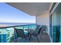 Balcony features a table and chairs with an ocean view beyond the balcony railing at 1903 S Ocean Blvd. # 701, North Myrtle Beach, SC 29582