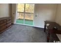 Carpeted bedroom featuring sliding glass doors leading to a balcony, dresser, and a table at 300-F Myrtle Greens Dr. # 300-F, Conway, SC 29526