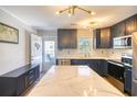 Modern kitchen features stainless appliances, quartz counters, and stylish cabinetry with door leading to outdoor patio at 308 24Th Ave. N, North Myrtle Beach, SC 29582