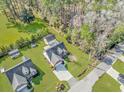 An aerial view showcases the house's backyard, nearby neighborhood, driveway, and landscaping at 359 Rose Ave., Georgetown, SC 29440