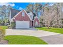 Two-story brick home featuring an attached garage, long driveway, and well-maintained lawn at 359 Rose Ave., Georgetown, SC 29440