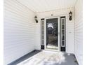 Inviting front porch features a storm door, sconce lighting, and space for personalized decor at 4030 Manor Wood Dr., Myrtle Beach, SC 29588