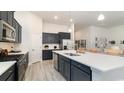 Modern kitchen featuring navy cabinets, stainless steel appliances, and a large quartz island at 418 Clear Lake Dr., Conway, SC 29526