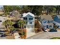 Aerial view of a three-story home with lush landscaping, showcasing the double garage at 4762 Cloister Ln., Myrtle Beach, SC 29577