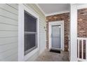 Entrance to a condo with brick and siding, a storm door, and an exterior light fixture at 4889 Magnolia Pointe Ln. # 105, Myrtle Beach, SC 29577