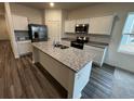 Modern kitchen island with granite countertops, stainless steel appliances and hardwood flooring at 516 Tillage Ct., Conway, SC 29526