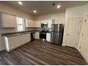 Modern kitchen with white cabinets, stainless steel appliances, granite countertops, and wood-look flooring at 536 Tillage Ct., Conway, SC 29526