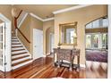 Elegant foyer featuring hardwood floors, staircase, and a decorative console table with mirror at 6575 Sw Longwater Ct., Ocean Isle Beach, NC 28469