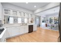 Bright kitchen featuring white cabinets, modern appliances, and hardwood floors leading to an open dining area at 7624 Azure Dr., Myrtle Beach, SC 29572