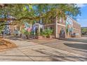 An eye-level exterior view of a two-story brick building with flags and a large tree providing shade at 805 Francis Parker Rd., Georgetown, SC 29440