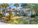 Beautiful single-story home with a tiled roof, decorative entryway, and lush tropical landscaping at 8068 Cortona Dr., Myrtle Beach, SC 29572