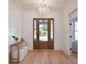 Inviting foyer featuring a decorative chandelier, wood floors, and a clear view through the front door at 1328 Foxtail Dr., Longs, SC 29568