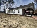 View of the house with white siding and a drive way with a golf cart parked underneath it at 160 Leadwood St., Andrews, SC 29510