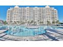 Beautiful outdoor swimming pool in front of condominium complex with palm trees and blue sky at 2151 Bridge View Ct. # 11003, North Myrtle Beach, SC 29582