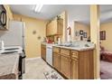 A compact kitchen with light wood cabinetry, white appliances, and a neutral countertop at 2276 Essex Dr. # H, Surfside Beach, SC 29575