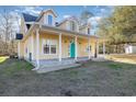 View of the inviting covered porch with white columns and a vibrant teal front door at 2724 A C Ln, Conway, SC 29526