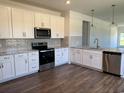 Modern kitchen with stainless steel appliances, white cabinetry, and granite countertops at 4000 Braid Ct., Myrtle Beach, SC 29588