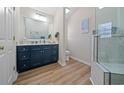 Bright bathroom with a modern vanity, wood-look floors, and tiled glass shower for a spa-like feel at 4239 Rivergate Ln., Little River, SC 29566