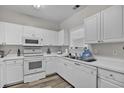 Bright kitchen featuring white cabinets, countertops, and appliances, with a window over the sink at 5801 Oyster Catcher Dr. # 822, North Myrtle Beach, SC 29582