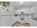 Well-lit kitchen with all-white appliances and cabinets and modern hardware, with an archway feature at 5801 Oyster Catcher Dr. # 822, North Myrtle Beach, SC 29582