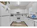 Bright kitchen featuring white cabinets, countertops, and appliances, with a window over the sink at 5801 Oyster Catcher Dr. # 822, North Myrtle Beach, SC 29582