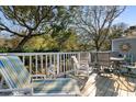 Relaxing deck with outdoor seating, lounge chairs, and tranquil views of the surrounding trees and foliage at 601 Gloucester Terrace Circle # 3C, Myrtle Beach, SC 29572