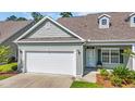 Charming home featuring a white garage door, a quaint porch, and a professionally landscaped front yard at 662 Sunnyside Dr. # 101, Murrells Inlet, SC 29576