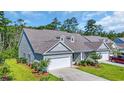 Beautiful home with a two-car garage, well-kept lawn, and professionally landscaped front yard, nestled in a wooded community at 662 Sunnyside Dr. # 101, Murrells Inlet, SC 29576