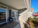 Inviting front porch featuring a chair, accent table, and manicured landscaping, creating a welcoming entrance at 662 Sunnyside Dr. # 101, Murrells Inlet, SC 29576