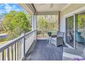 Relaxing covered balcony featuring outdoor seating and views of the surrounding greenery at 670 Riverwalk Dr. # 304, Myrtle Beach, SC 29579