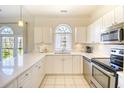 Bright kitchen featuring white cabinets, stainless steel appliances, and tile flooring at 670 Riverwalk Dr. # 304, Myrtle Beach, SC 29579