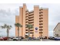 Exterior of the Carolina Reef condo building with palm trees in front of the parking area at 1501 S Ocean Blvd. # 504, North Myrtle Beach, SC 29582