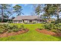 Inviting exterior showcasing landscaped grounds, manicured lawn, and classic brick architecture at 1616 Hawthorn Dr., Pawleys Island, SC 29585