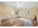 Spacious living room featuring hardwood floors, neutral paint, a ceiling fan, and an open door at 177 Reef Run Rd., Pawleys Island, SC 29585