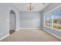 Well-lit living room with a large window, neutral carpet, and arched doorway at 228 Gresham Ln., Myrtle Beach, SC 29588