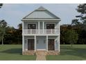 New construction home showcasing a two-story design with a charming front porch and brick foundation at 237 Madison Dr., Georgetown, SC 29440