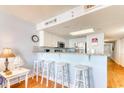 Efficient kitchen design with a breakfast bar, white cabinetry, and stainless steel appliances at 2801 S Ocean Blvd. # 733, North Myrtle Beach, SC 29582