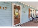 Inviting front porch with a beautifully detailed wooden door, rocking chairs, and a view of the house number at 317 14Th Ave. N, Surfside Beach, SC 29575