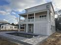 Rear exterior view of white coastal home with pool and spacious porch at 318 Vista Dr., Murrells Inlet, SC 29576