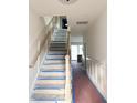 Staircase with white risers, wood railing, wainscoting and natural light at 318 Vista Dr., Murrells Inlet, SC 29576