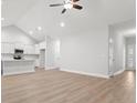 Spacious living room leading into kitchen, hardwood floors, white walls, and ceiling fan at 383 West Dogwood Rd., Loris, SC 29569