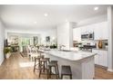 Open-concept kitchen flowing into the living room, featuring white cabinets and stainless steel appliances at 448 Ribbon Rail Way, Loris, SC 29569