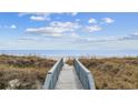 Beach access showing the wooden walkway through the grassy dunes to the sandy beach at 817 S Ocean Blvd. # 105, North Myrtle Beach, SC 29582