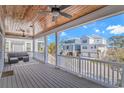 Comfortable outdoor seating on a covered porch with a stained-wood ceiling and neighborhood views at 89 Enclave Pl., Pawleys Island, SC 29585