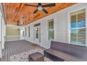 Inviting covered porch with comfortable wicker furniture and a stained-wood ceiling with fans at 89 Enclave Pl., Pawleys Island, SC 29585