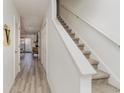 Hallway with hard wood floors that leads into living room with fireplace and staircase with white railing at 1025 Carolina Rd. # Cc2, Conway, SC 29526