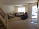 Living room features neutral walls, carpet, two sofas, a recliner, and a front door with natural light at 1027 Pinwheel Loop # 3103, Myrtle Beach, SC 29577