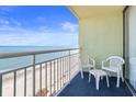 Balcony with ocean view, featuring white plastic chairs and a small table for relaxing at 1105 S Ocean Blvd. # 1210, Myrtle Beach, SC 29577