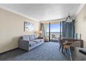 Comfortable living area with a sofa, dining table, and balcony access with ocean views at 1105 S Ocean Blvd. # 1210, Myrtle Beach, SC 29577